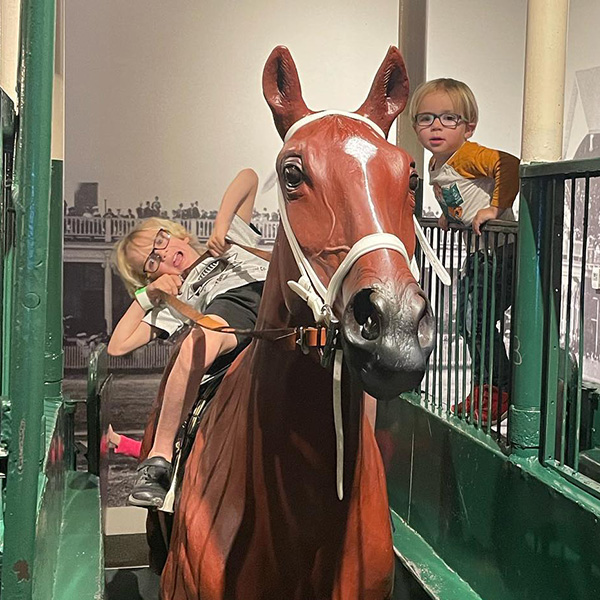 Kids on model horse in starting gate